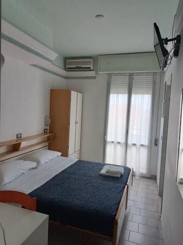 een kleine slaapkamer met een bed en een raam bij HOTEL AUGUSTUS in Gatteo a Mare
