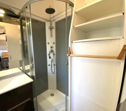 La salle de bains est pourvue d'une cabine de douche en verre. dans l'établissement Chalet situé dans un camping 4 étoiles - 4 à 6 personnes - KIRIO, à Guidel