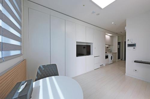a dining room with a table and a television in a room at World Sky Residence Hotel in Sokcho