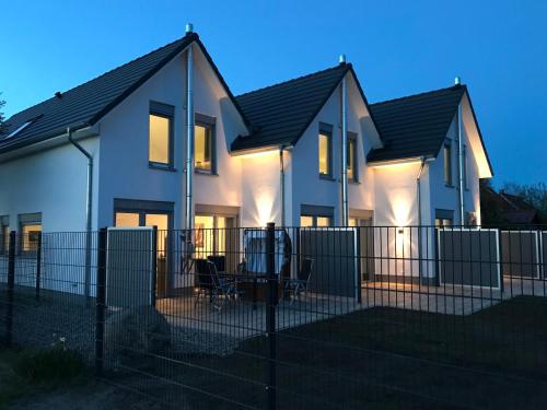 a house with a fence in front of it at The Fehmarn Lodges - RELAX - in Fehmarn