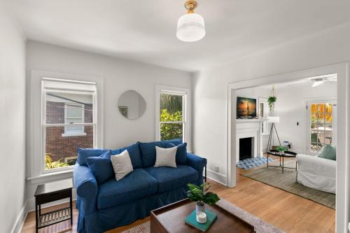 Una sala de estar con un sofá azul y una chimenea. en SoHo Siesta Stunning Apt w Private Balcony, en Tampa