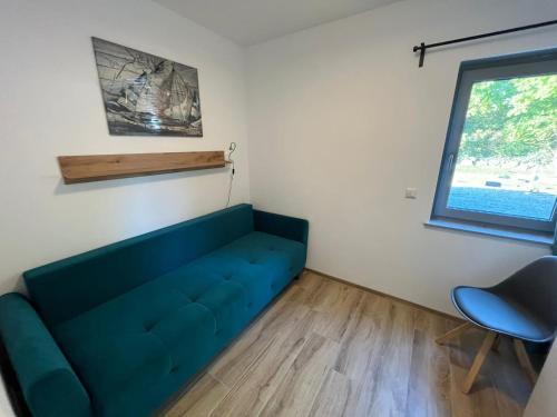 a blue couch in a room with a window at The Fehmarn Lodges - OASIS - in Fehmarn