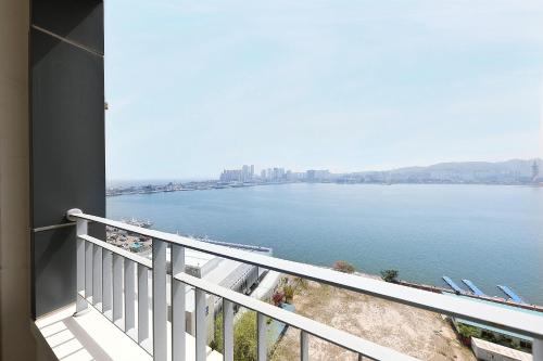 a balcony with a view of a large body of water at World Sky Residence Hotel in Sokcho