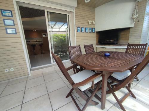 une table et des chaises en bois sur une terrasse dans l'établissement Villa 17, Cap Sauvage au village naturiste, au Cap d'Agde