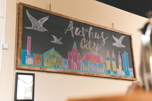 a chalkboard with a painting of a city at Danhostel Aarhus City in Aarhus