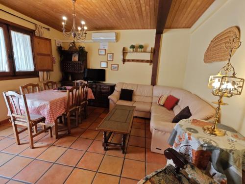 uma sala de estar com um sofá e uma mesa em Casa Rural TioMoreno by Naturadrada em La Adrada