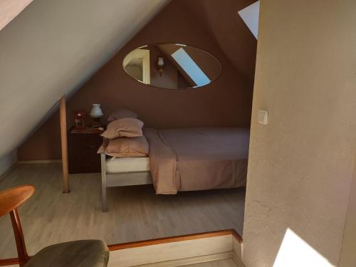 - une petite chambre avec un lit et un miroir dans l'établissement Loft 'PRL', à Tykocin