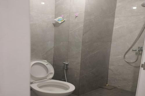 a bathroom with a toilet and a shower at Capital O 93854 Apartemen Sayana By Sentra Jaya in Bekasi