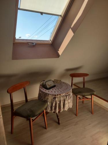ティコチンにあるLoft 'PRL'のテーブルと椅子2脚、窓が備わる客室です。