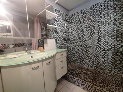 une salle de bain avec un lavabo et une douche dans l'établissement Villa 17, Cap Sauvage au village naturiste, au Cap d'Agde