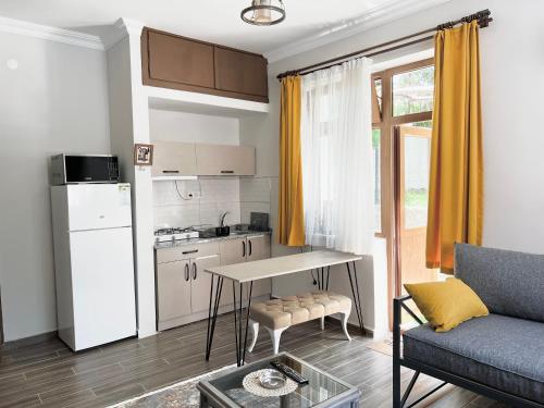 a kitchen and a living room with a table and a couch at Konukzade OldTown Apart in Antalya