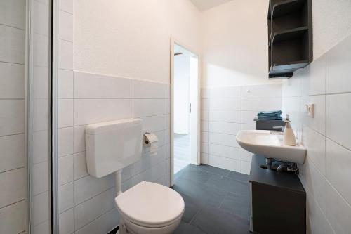 uma casa de banho branca com um WC e um lavatório em Wendelin em Sankt Wendel