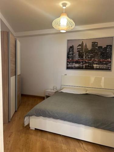 a bedroom with a bed and a painting on the wall at Palm Beach apartment Bissone in Bissone