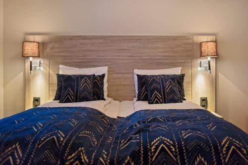 a bedroom with a bed with a blue and white comforter at Radisson Blu Polar Hotel, Spitsbergen in Longyearbyen