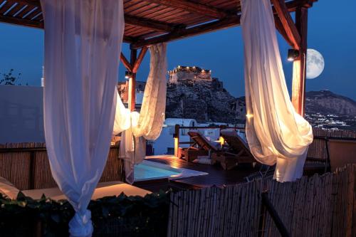 a view of the acropolis from a house with white curtains at Santorini Rooftop Hot Tub Suite with Panoramic Views in Akrotiri