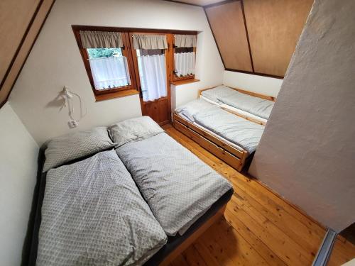 a small bedroom with two beds in a room at Chata Mezičky in Jiřetín pod Jedlovou