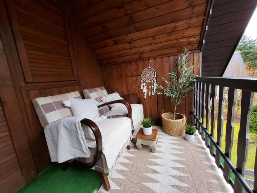 a porch with a bed and potted plants on it at Chata Mezičky in Jiřetín pod Jedlovou