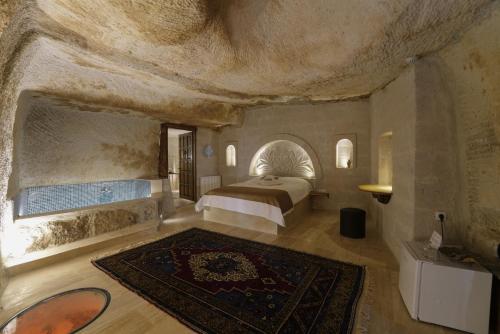 1 dormitorio con 1 cama en una pared de piedra en My Cave Suites en Nevşehir