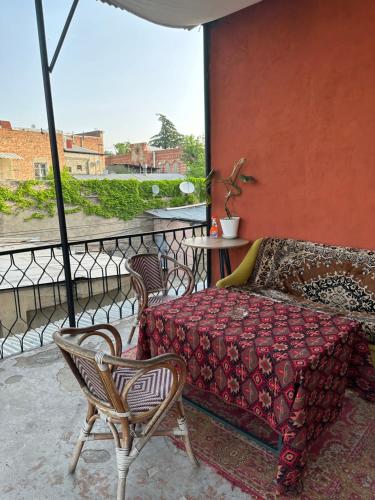 uma varanda com um sofá, uma mesa e cadeiras em Nina’s Sweet Home em Tbilisi
