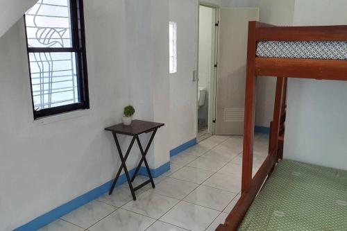 een kamer met een stapelbed en een tafel bij Family Room near Kawasan Falls in Matutinao