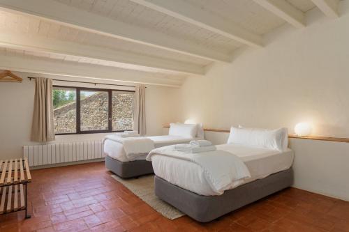 1 dormitorio con 2 camas y ventana en Flateli Corçà, en Corçà