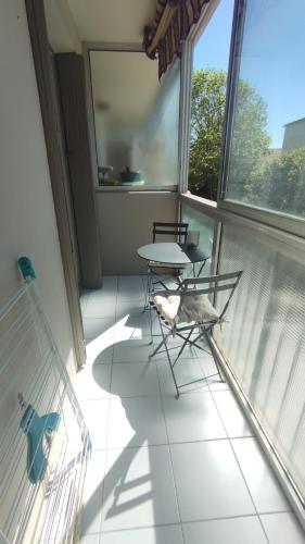 einen Balkon mit einem Tisch und Stühlen in einem Zimmer in der Unterkunft T2 -Six Fours - 300m plage in Six-Fours-les-Plages