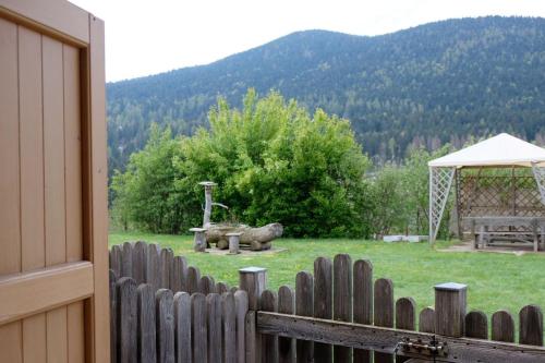 een houten hek met een tuinhuisje in een veld bij B&B Longanorbait in Folgaria