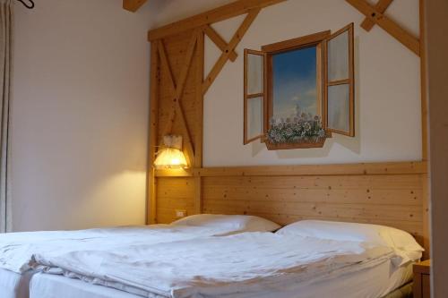 een slaapkamer met 2 bedden en een raam bij B&B Longanorbait in Folgaria