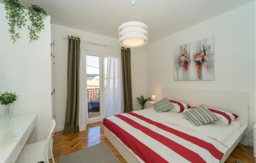 een slaapkamer met een bed met een rode en witte gestreepte deken bij Amazing Apartment In Vela Luka With Kitchen in Vela Luka