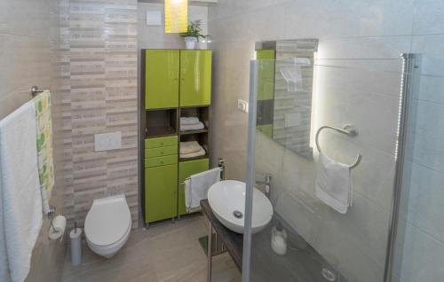 een badkamer met een wit toilet en een groene kast bij Amazing Apartment In Vela Luka With Kitchen in Vela Luka