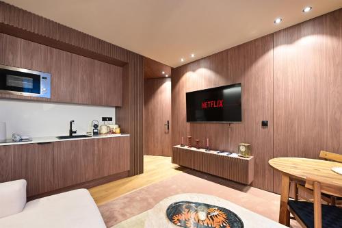 a living room with a tv on a wooden wall at Luxueux Logement Grand Place et Opéra clim by Lity in Lille