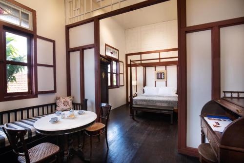 a room with a table and chairs and a bed at Muntri Mews in George Town