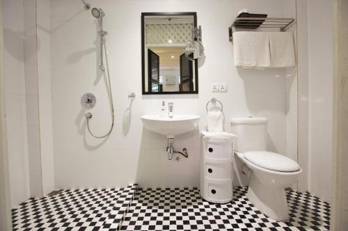 Baño blanco con lavabo y aseo en Muntri Mews en George Town