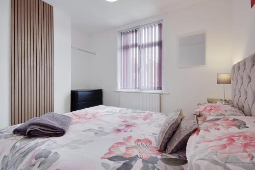 Wimbourne Road Apartment 2 في بورنموث: غرفة نوم مع سرير مع لحاف متهالك