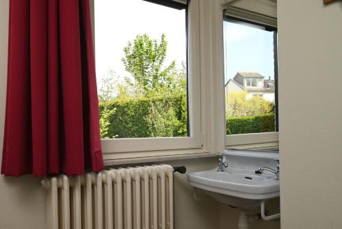 baño con lavabo y 2 ventanas en Nor Saga - Hennequinlaan 10, en Cadzand