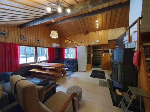 a living room with a table and a fireplace at Kelotupa 19 in Syöte