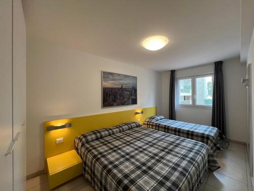 een slaapkamer met 2 bedden en een raam bij Appartamenti Mare in Lignano Sabbiadoro