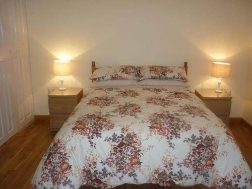 - une chambre avec un lit et deux lampes de chaque côté dans l'établissement Glenview Lodge accommodation, Monmouthshire, à Usk