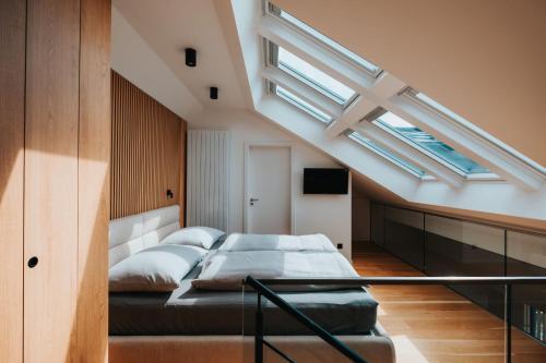 a loft bedroom with a bed and skylights at MOLO LIPNO RESIDENCE in Lipno nad Vltavou