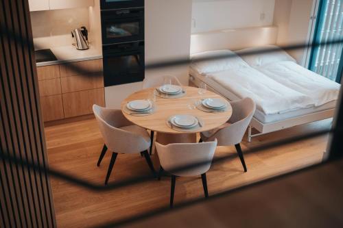 a table with chairs and a bed in a room at MOLO LIPNO RESIDENCE in Lipno nad Vltavou