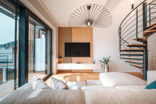 a living room with a couch and a tv at MOLO LIPNO RESIDENCE in Lipno nad Vltavou