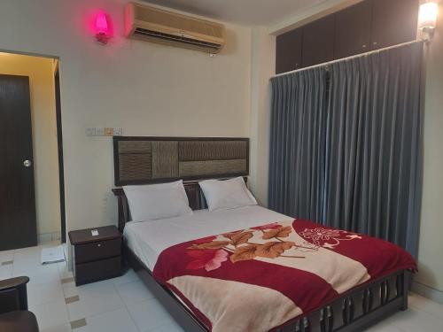 sypialnia z dużym łóżkiem i czerwonym kocem w obiekcie Allegro Suites, Cox's Bazar w mieście Koks Badźar