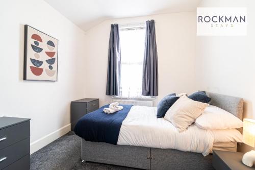 a bedroom with a bed and a window at 32 The Grove - Modern & Elegant Home Close to Beach with Parking by RockmanStays in Southend-on-Sea