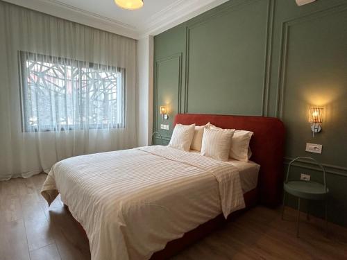 a bedroom with a large bed with white sheets and a window at Studio cosy chic in Casablanca