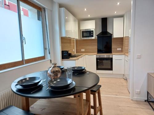 une cuisine avec une table recouverte de plaques noires dans l'établissement Élégant, spacieux, 2 couchages, proche centre, à Amiens