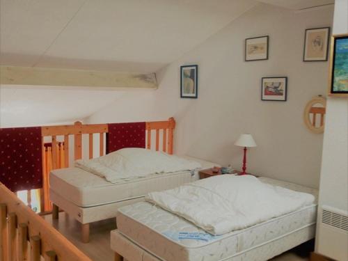 two twin beds in a room with a staircase at Appartement Soustons, 2 pièces, 4 personnes - FR-1-379-110 in Soustons