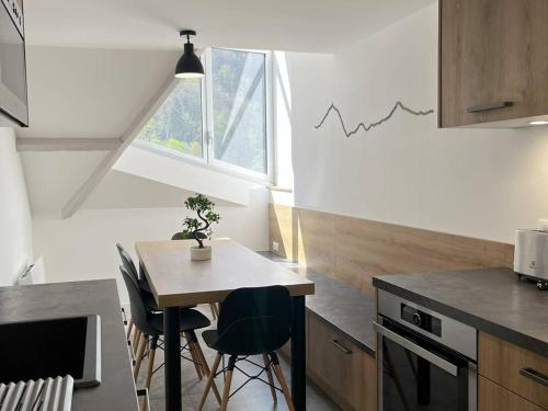 une cuisine avec une table et des chaises dans une pièce dans l'établissement Appartement T4 rénové, proche centre, 3 chambres, 6/8 pers, équipé, est/ouest, dispo de suite - FR-1-234-254, à Cauterets