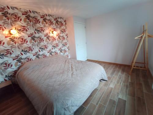 - une chambre avec un lit et un mur fleuri dans l'établissement Maison a la Laiterie, à La Gaubretière