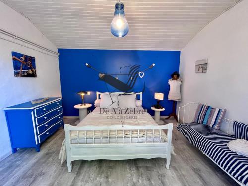 a bedroom with a bed and a blue wall at Ma Cabane - Agréable maison idéalement située in La Tremblade