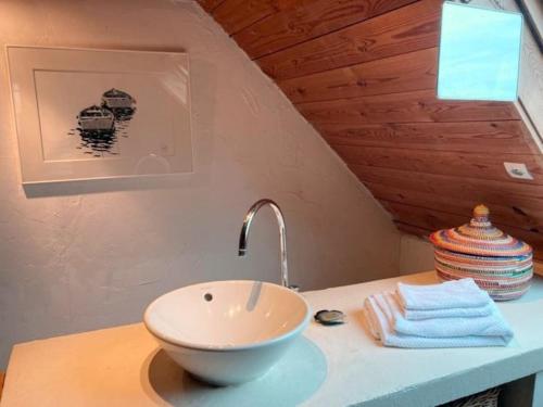La salle de bains est pourvue d'un lavabo sur un comptoir. dans l'établissement Maison de pêcheur proche plage et activités, à Crozon